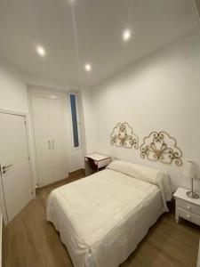 Habitación blanca con cama y mesita de noche en Bonito y acogedor apartamento pleno centro Granada, en Granada