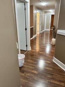an empty living room with wood floors and a hallway at 7BDRM Pet Friendly 3Car Garage Home Sleeps18 in Edmonton