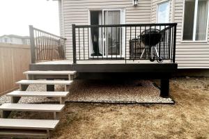 a porch with a grill and stairs next to a house at 7BDRM Pet Friendly 3Car Garage Home Sleeps18 in Edmonton