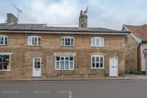 a brick house with white doors and windows at The Old Shop, No 12 in Framlingham