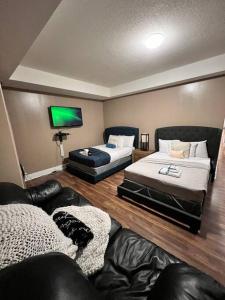 a living room with two beds and a couch at 7BDRM Pet Friendly 3Car Garage Home Sleeps18 in Edmonton