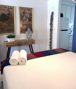 サンファンにあるKASA Galicia by the Sea - Cabana Studio Apt for 2 BEACHFRONT CONDO POOLのベッドにタオル2枚を用意しています。