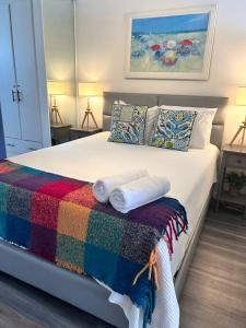 サンファンにあるKASA Galicia by the Sea - Cabana Studio Apt for 2 BEACHFRONT CONDO POOLのベッドルーム1室(カラフルな毛布と枕付きのベッド1台付)