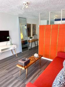 a living room with a red couch and a table at KASA Galicia by the Sea - Cabana Studio Apt for 2 BEACHFRONT CONDO POOL in San Juan
