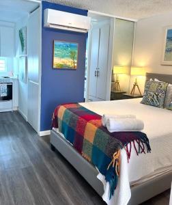サンファンにあるKASA Galicia by the Sea - Cabana Studio Apt for 2 BEACHFRONT CONDO POOLのベッドルーム1室(カラフルな毛布付きのベッド1台付)