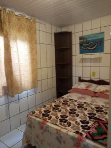 1 dormitorio con cama y ventana en Residencial Lena a 300 metros da praia, en Florianópolis