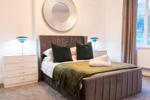 a bedroom with a large bed with a mirror on the wall at Mapperley Park Guesthouse in Nottingham