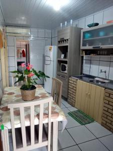 una cocina con una mesa con una planta en Residencial Lena a 300 metros da praia, en Florianópolis