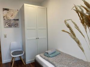 a bedroom with a bed and a chair at 7-24 Self-Check-In - 120qm - 5 rooms - 2 bathrooms - kitchen - free parking - Yihapartment in Hannover +24 photos