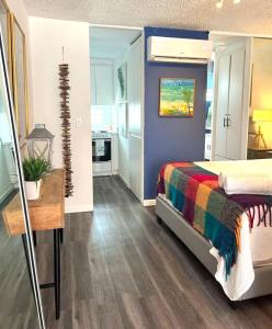 a bedroom with a bed with a colorful blanket at KASA Galicia by the Sea - Cabana Studio Apt for 2 BEACHFRONT CONDO POOL in San Juan