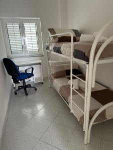 een kamer met een stapelbed, een stoel en een raam bij casa vacanza Maria in Napels
