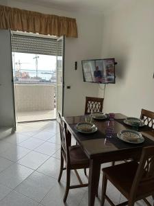 een eetkamer met een tafel en stoelen en een raam bij casa vacanza Maria in Napels