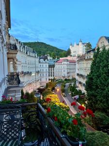 a view of a city with buildings and flowers on a balcony at Sadova luxury apartment in Karlovy Vary