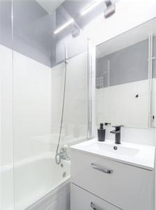 a white bathroom with a sink and a mirror at Millenium Apartment Self check-in Faktura in Rzeszów