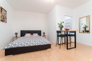 a bedroom with a bed and a table and a mirror at Millenium Apartment Self check-in Faktura in Rzeszów