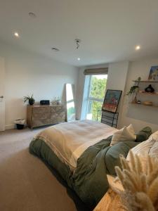 a bedroom with a large bed and a window at Stylish 1BR Apartment Next To Hampstead Heath in London