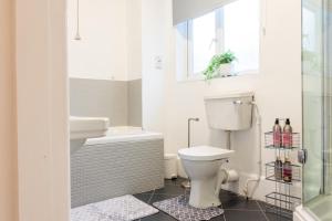 a bathroom with a toilet and a sink and a shower at Mapperley Park Guesthouse in Nottingham