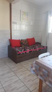 Habitación con cama con almohadas rojas. en Residencial Lena a 300 metros da praia, en Florianópolis