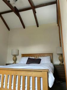 a bedroom with a wooden bed with two lamps at Rose Cottage Trecynon Traditional 2 bed cottage Zip World Beacons Bike in Aberdare