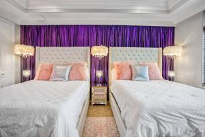 two beds in a bedroom with purple curtains at Posh Dtwn/Midtown Home w Stunning Roof-Top Terrace in Houston