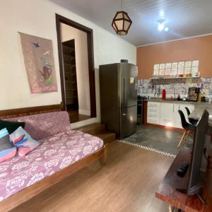 a living room with a couch and a refrigerator at Casa Solana - confortável, em rua calma, no centro do Rosa in Imbituba