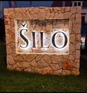 a sign on a stone wall with the word spell at Apartments Vugica Šilo in Šilo