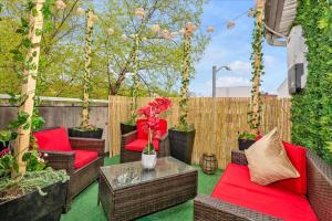 a patio with wicker chairs and a table with red cushions at Brooklyn Red Door in Brooklyn