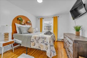 Schlafzimmer mit einem Bett und einem Flachbild-TV in der Unterkunft Brooklyn Red Door in Brooklyn