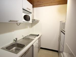 a white kitchen with a sink and a refrigerator at Appartement Chamrousse, 2 pièces, 6 personnes - FR-1-549-109 in Chamrousse