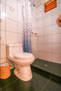La salle de bains est pourvue de toilettes et d'un rideau de douche bleu. dans l'établissement Eco Hacienda Roman, à Machu Picchu