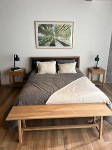 ein Schlafzimmer mit einem Bett mit einer Holzbank darauf in der Unterkunft Moderno depto en mejor zona gastronómica! in Manuel Alberti