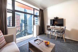 a living room with a table and a large window at Quest On The Terrace Serviced Apartments in Wellington