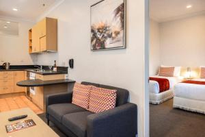 a kitchen and a living room with a couch and a bed at Quest On The Terrace Serviced Apartments in Wellington