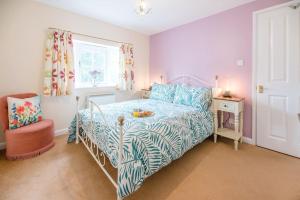 a bedroom with a bed with a blue and white comforter at No. 10 & 12 Bridge Street in Framlingham