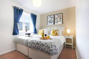 a bedroom with two beds with blue curtains at Appledore House - Close to City Centre - Free Parking, Fast Wifi, Private Garden and Smart TV with Netflix by Yoko Property in Milton Keynes