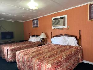 a hotel room with two beds and a tv at Sands Motel in Marianna
