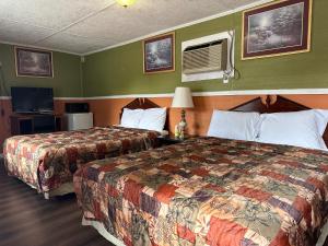 a hotel room with two beds and a tv at Sands Motel in Marianna