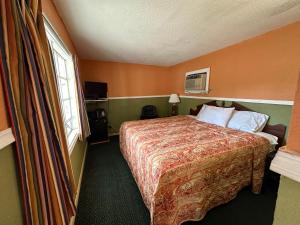 a hotel room with a bed and a window at Sands Motel in Marianna