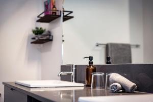 a kitchen counter with a sink and a bottle of wine at The Three Bear Penthouse - with Hot Tub in Revelstoke +44 photos