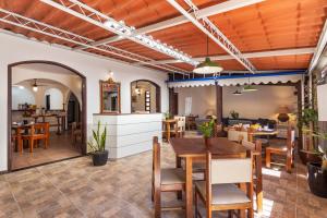 a dining room and living room with a table and chairs at Pousada Via Mar Búzios in Búzios