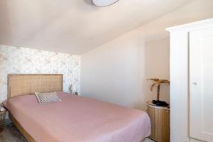 a bedroom with a bed with a pink blanket at Casa Tropicana in Paul do Mar