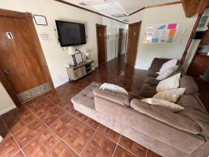 uma sala de estar com um sofá e uma televisão de ecrã plano em Alojamiento Los Andes em Brownsville