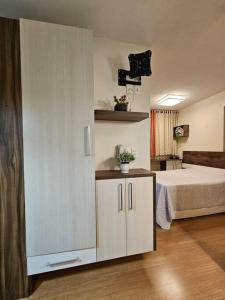 een slaapkamer met een bed en een witte kast bij Loft Premier Centro e 800 mt da Oktoberfest. in Blumenau