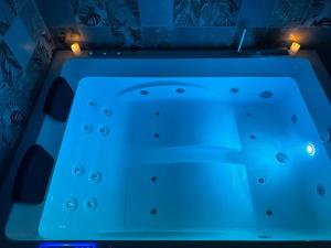 bañera azul en una habitación con luces en Les pieds dans l'eau TROPICANA, en Corné