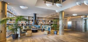 a lobby with blue chairs and potted plants at Hilton Auckland in Auckland