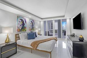 Habitación blanca con cama y TV en Funkin' Fabulous! Water & City Views! 4BR, en Miami