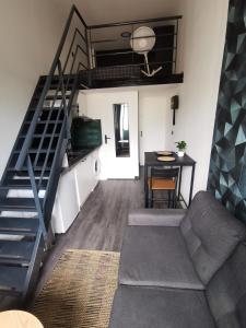 ein Wohnzimmer mit einer Treppe, einem Sofa und einem Tisch in der Unterkunft Studio mezzanine Lyon in Villeurbanne