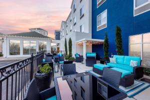 a patio with blue chairs and tables on a building at Hilton Garden Inn Albuquerque/Journal Center in Albuquerque