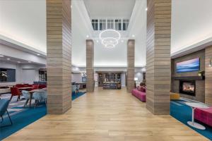 a lobby with a fireplace and tables and chairs at Hilton Garden Inn Albuquerque/Journal Center in Albuquerque