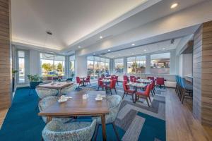 a restaurant with tables and chairs and windows at Hilton Garden Inn Albuquerque/Journal Center in Albuquerque